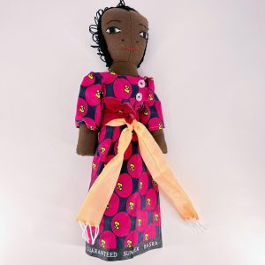 African Doll wearing a gomesi dress